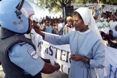An East Timorese nun gives a piece of candy to a soldier during an anti-government protest